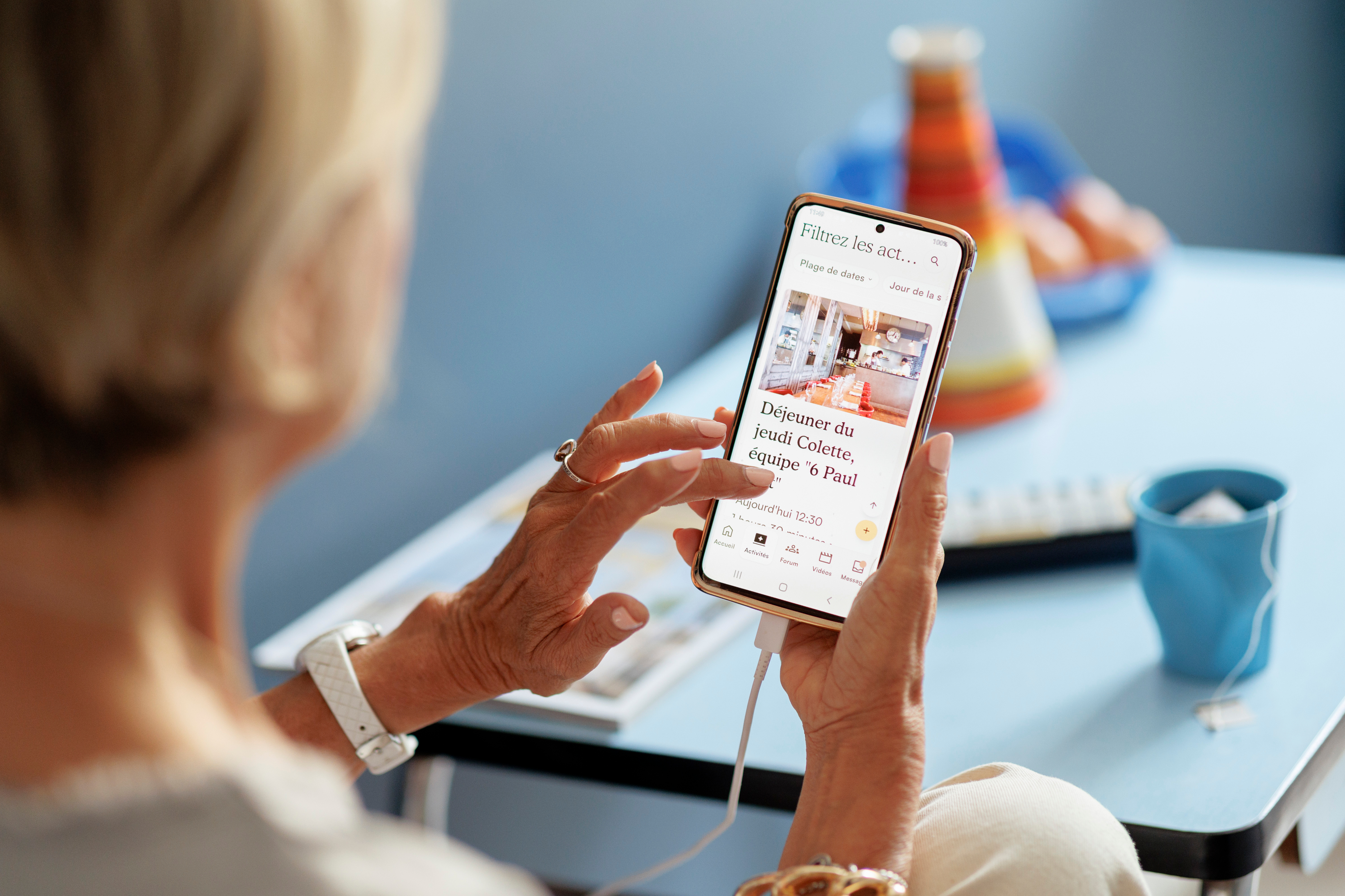 Une femme senior utilisant l'application Colette sur son téléphone portable.